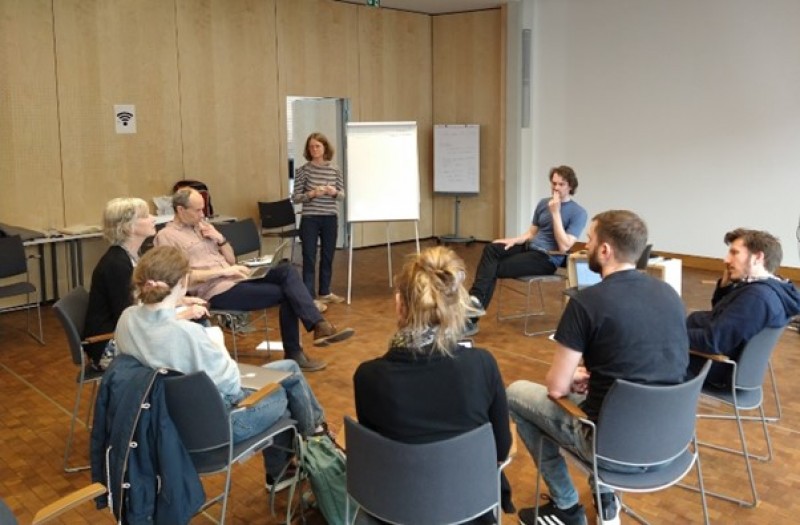 A person giving a presentation to a group of peopleDescription automatically generated with medium confidence